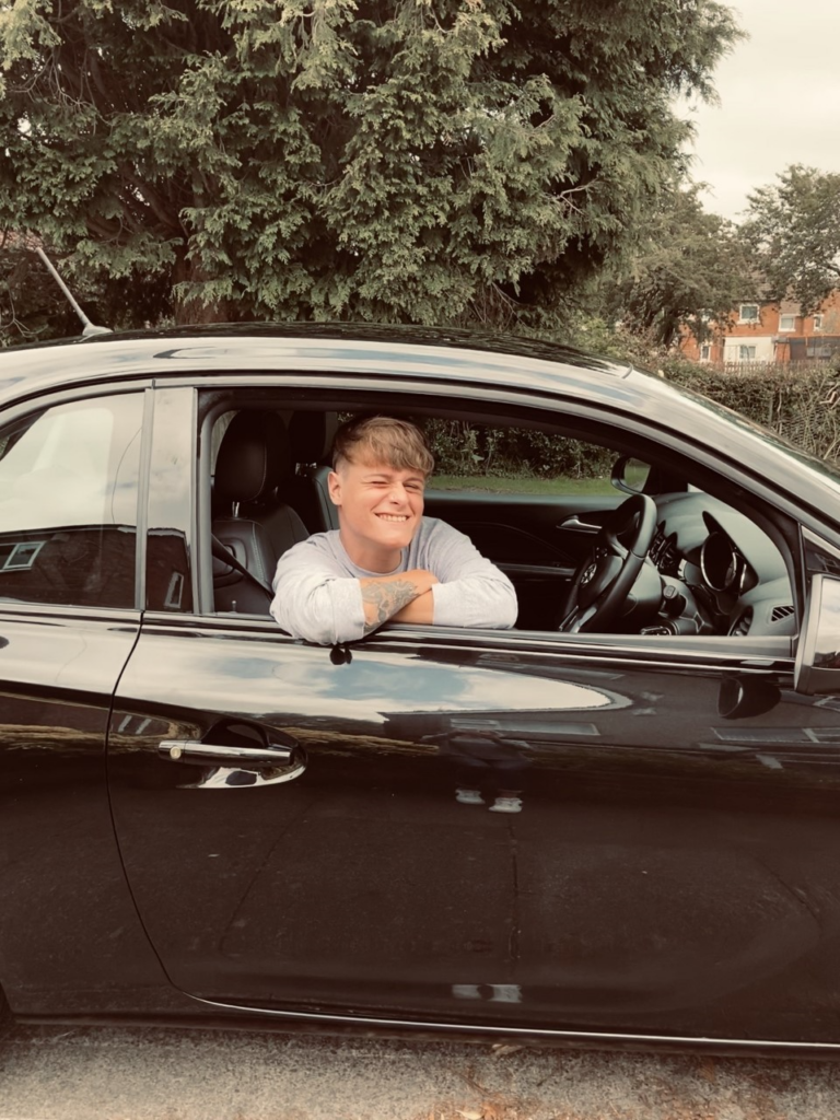 Picture of Matt in the driving seat of a black car.