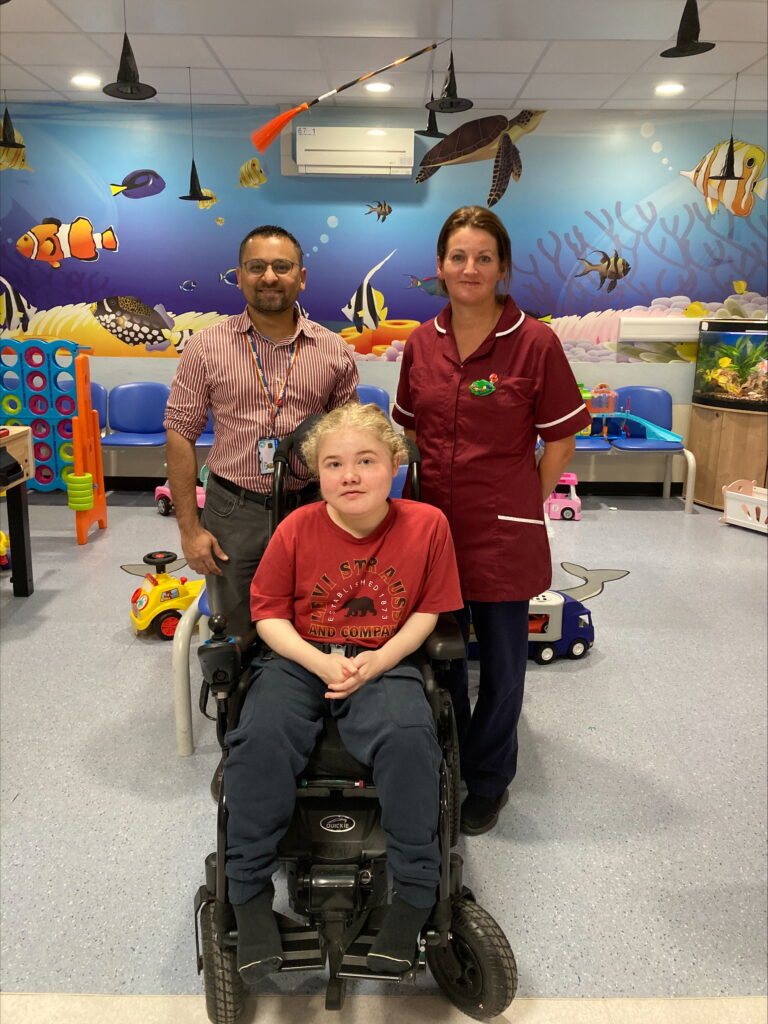 Dr Khushnood and Kathryn Bell, research nurse, are stood behind Robert in a waiting room 