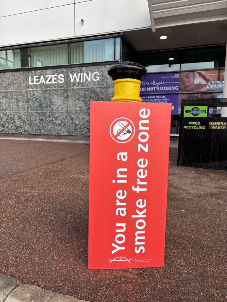 Picture of a red bollard cover with the text "You are in a smoke free zone".