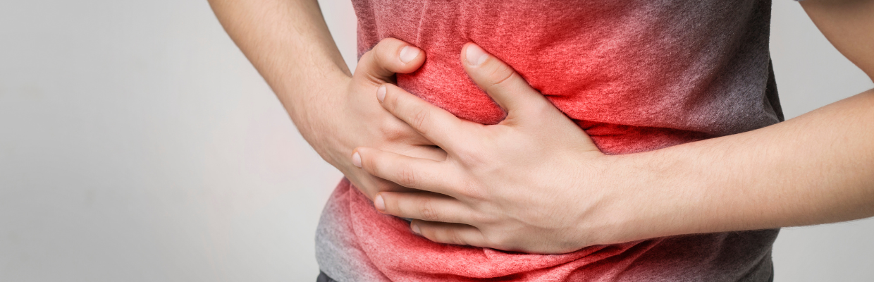 a person clutches their stomach. The stomach area is red to depict pain