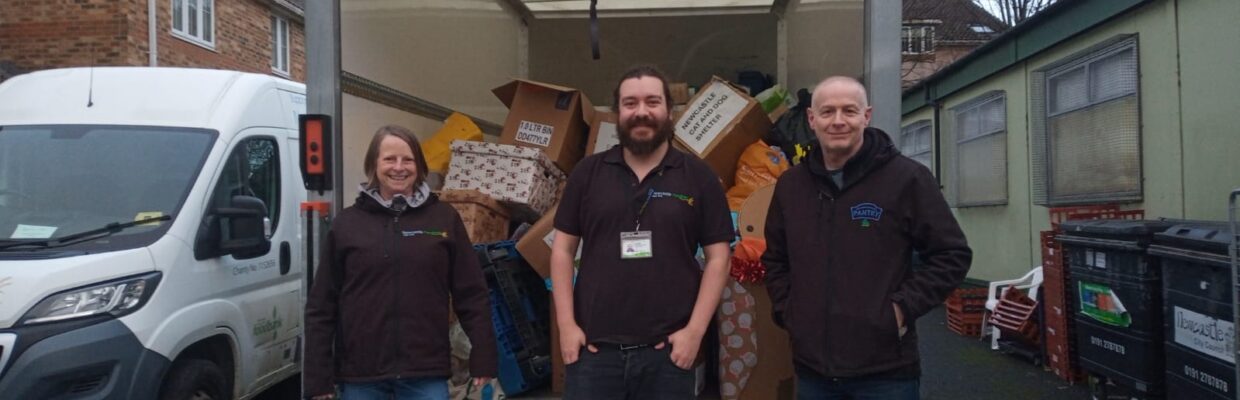 Picture of staff from Newcastle Foodbank stood on a removal van step with the boxes of donations in the van.